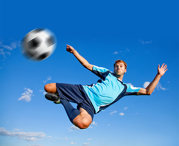 male soccer player doing a bicycle kick in midair