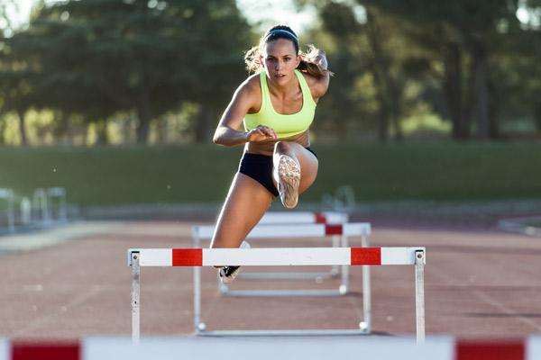 woman doing hurdles with right leg in the air